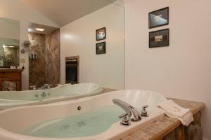 uma grande casa de banho com banheira e lavatório em The Lodge at Moosehead Lake em Greenville