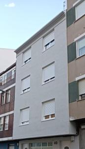 een wit gebouw met ramen aan de zijkant bij Herba de namorar- Céntrico apartamento en Cedeira in Cedeira