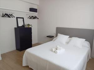 een slaapkamer met een wit bed en 2 handdoeken bij Herba de namorar- Céntrico apartamento en Cedeira in Cedeira