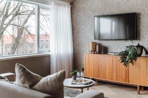 a living room with a tv on a wall at Havendijk Hotel in Schiedam