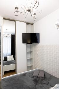 ワルシャワにあるClickTheFlat Old Town Apart Roomsのベッドルーム1室(大きな鏡、壁掛けテレビ付)