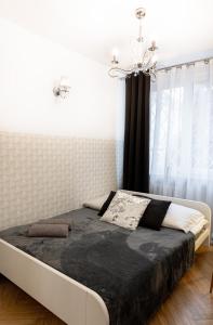 łóżko w sypialni z żyrandolem w obiekcie ClickTheFlat Old Town Apart Rooms w Warszawie