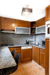 a kitchen with wooden cabinets and a table with chairs at ClickTheFlat Old Town Apart Rooms in Warsaw