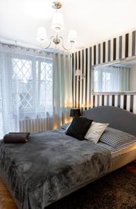 sypialnia z dużym łóżkiem i dużym oknem w obiekcie ClickTheFlat Old Town Apart Rooms w Warszawie