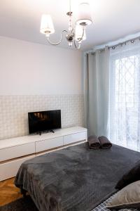 a bedroom with a tv on a white wall at ClickTheFlat Old Town Apart Rooms in Warsaw