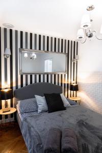 sypialnia z łóżkiem i ścianą w paski w obiekcie ClickTheFlat Old Town Apart Rooms w Warszawie