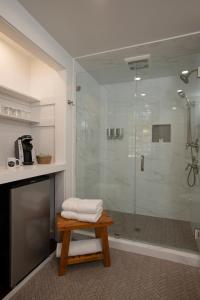 a bathroom with a shower with a bench and a table at The Lodge at Moosehead Lake in Greenville