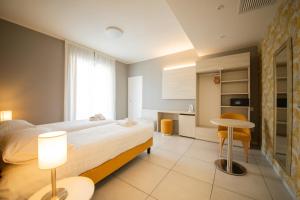 a bedroom with a bed and a table and a kitchen at Lei Rooms in Maranello