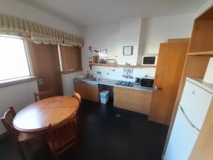 a kitchen with a wooden table and a table and chairs at HI Viana do Castelo - Pousada de Juventude in Viana do Castelo