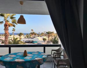 a room with a table and a view of the beach at Al Sole Studios residence Playa Roca in Costa Teguise