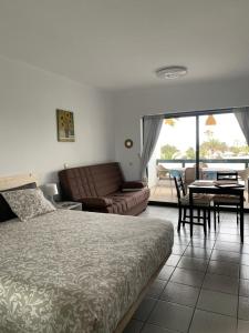 1 dormitorio con cama, sofá y mesa en Al Sole Studios residence Playa Roca, en Costa Teguise
