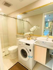 een badkamer met een wasmachine en een wastafel bij Royale at Azure North Bali Tower in San Fernando