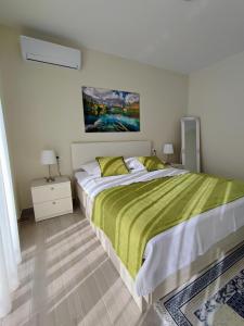 a bedroom with a large bed with a green blanket at Luxury Apartment Pape in Baška Voda