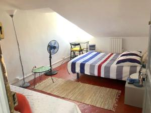 - une chambre avec un lit, un ventilateur et une table dans l'établissement Apt 2-3 pces dans le Carre d Or a 290 m des plages, à Nice