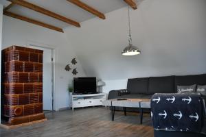 a living room with a black couch and a tv at Balders Bude 2 in Mönkebude