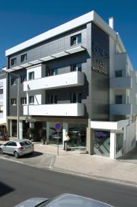 un bâtiment avec une voiture garée devant lui dans l'établissement Hotel Genesis, à Fátima