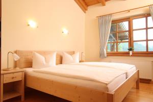 a bedroom with a large white bed with a window at Ante Romantikhof in Bromskirchen