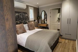 ein Schlafzimmer mit einem großen Bett und einem Schrank in der Unterkunft Cape Village Lodge in Durbanville