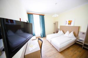 a hotel room with a bed and a flat screen tv at Hotel Lehenerhof in Salzburg