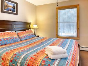 a bedroom with a large bed and a window at Cascade Mountain Chalet in Wilmington