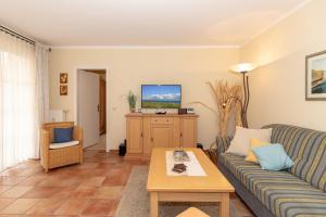 a living room with a couch and a tv at Haus-Ostseewelle-Wohnung-13-312 in Kühlungsborn