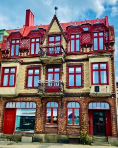 un gran edificio de ladrillo con ventanas rojas. en Hotell Blanka- Lägenhet- Boutique Hotell, en Varberg