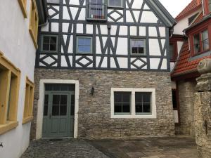 um edifício preto e branco com uma porta verde em Ferienwohnung Mainidylle em Winterhausen