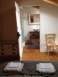 een slaapkamer met een wastafel, een bed en een stoel bij Casa di Susa in San Giuliano
