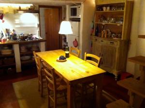 a kitchen with a wooden table with a bottle of wine at Casa di Susa in San Giuliano