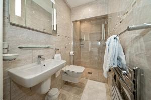 a bathroom with a white sink and a toilet at Serviced Apartments Macclesfield in Macclesfield