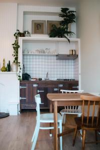 a kitchen with a wooden table and chairs and a table at Appartement 'de Stadstuin' in Harderwijk