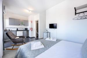 ラゴスにあるStay on Top Apartmentsのベッドルーム1室(ベッド1台、椅子1脚付)、キッチン