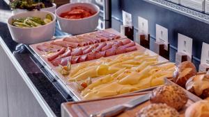 un buffet con queso, carne y otros alimentos en Holiday Inn Express Frankfurt Airport, an IHG Hotel, en Mörfelden-Walldorf