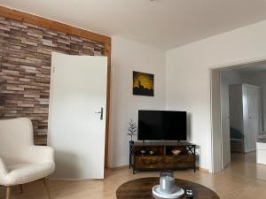 een woonkamer met een televisie en een witte deur bij Fewo 1 - a79673 in Maagdenburg