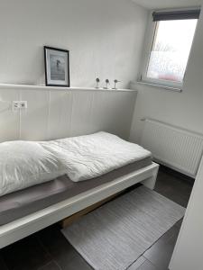 een witte slaapkamer met een bed en een raam bij Fewo 1 - a79673 in Maagdenburg