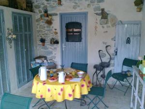 einen Tisch mit einem gelben Tischtuch in einem Zimmer in der Unterkunft La Bastide des Sources in Le Castellet