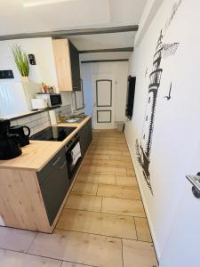 cocina con suelo de madera y cocina con escalera en Ferienwohnung „Deichgeflüster“ nahe der Nordsee, en Marne