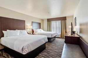 a hotel room with two beds and a window at Cobblestone Hotel & Suites - Ottumwa in Ottumwa