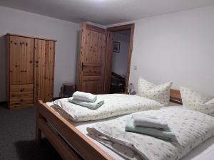 a bedroom with two twin beds and wooden cabinets at Restaurant & Pension Forsthaus Hain in Kurort Oybin