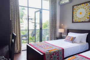 um quarto com uma cama e uma varanda em Kandy City View em Kandy