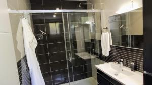 a black tiled bathroom with a shower and a sink at Luxury Apartment Pape in Baška Voda +28 photos