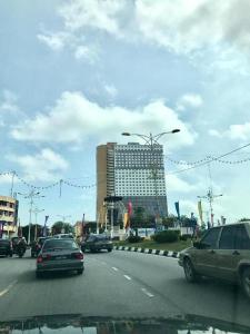 eine Straße mit Autos, die eine Straße mit einem Gebäude befahren in der Unterkunft Eli Homestay in Kuala Terengganu