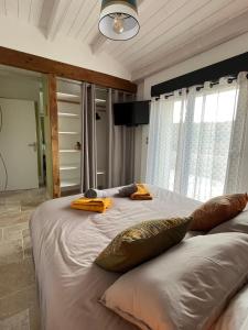 a bedroom with a large bed with two pillows on it at Chambre au calme avec spa privatif gratuit sud aveyron les palmiers des causses in Saint-Rome-de-Tarn