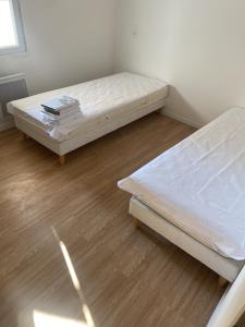 Duas camas num quarto com pisos em madeira em Maison Montblanc em Montblanc