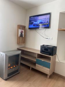 ein Wohnzimmer mit einem TV und einem Kamin in der Unterkunft Maison Montblanc in Montblanc