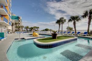 uma piscina com cadeiras azuis e palmeiras em Atlantica 11th Floor Gem! em Myrtle Beach