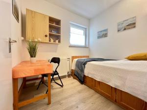a bedroom with a bed and a desk and a table at Haus am Deich Wohnung 13 in Dahme