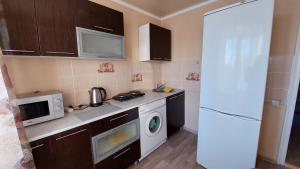 cocina con nevera blanca y microondas en 2 комнатная квартира, en Shchūchīnsk