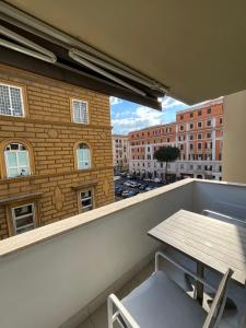 - un balcon avec une table, des chaises et des bâtiments dans l'établissement Monolocale, à Rome