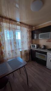 una pequeña cocina con mesa en una habitación en 2 комнатная квартира, en Shchūchīnsk